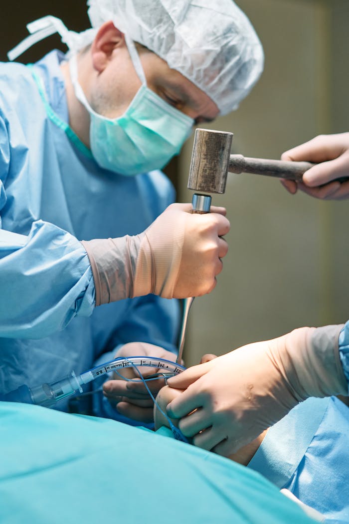 Medical professionals performing surgery with precision tools in a sterile environment.